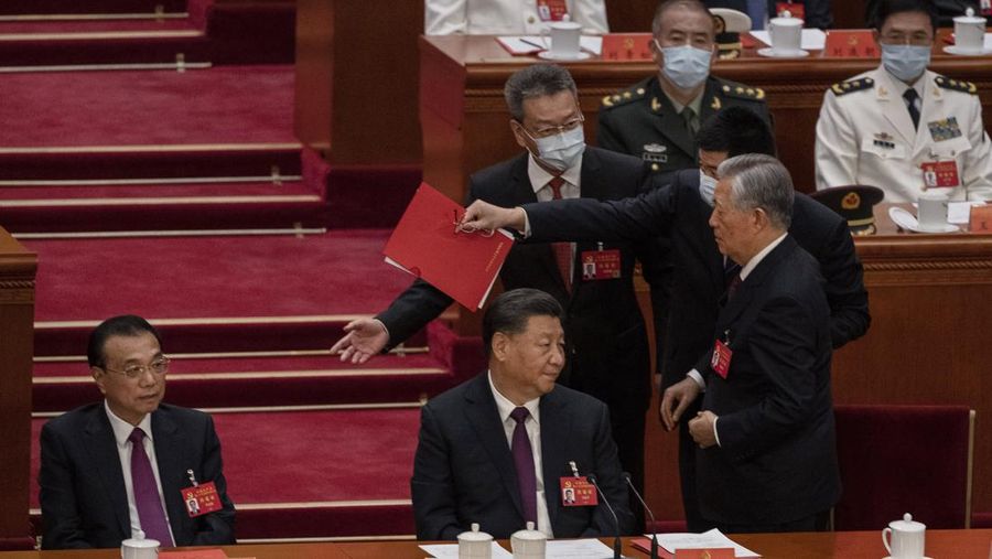 Presiden Tiongkok Xi Jinping, kanan, mendengarkan bantuan saat dia duduk di sebelah Perdana Menteri Li Keqiang selama sesi penutupan Kongres Nasional Partai Komunis Tiongkok ke-20, di Aula Besar Rakyat pada Oktober 22, 2022 di Beijing, Cina. (Getty Images/Kevin Frayer)
