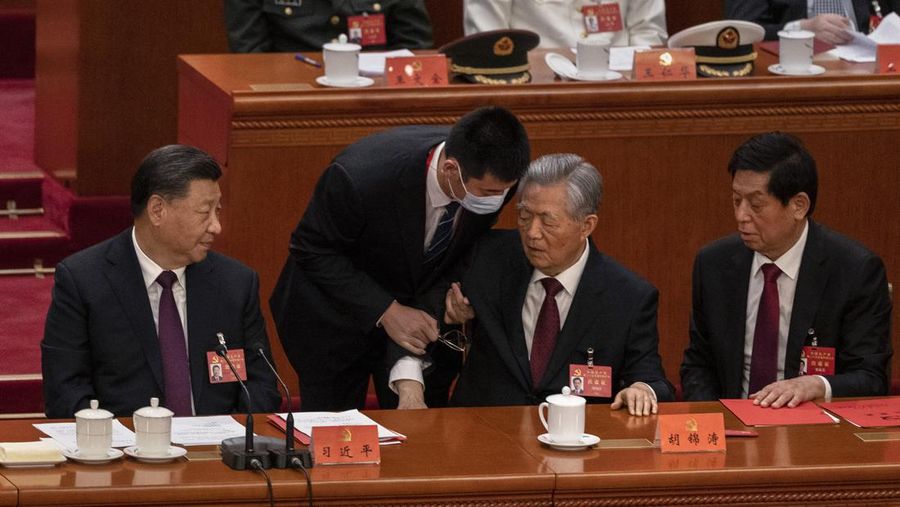 Presiden Tiongkok Xi Jinping, kanan, mendengarkan bantuan saat dia duduk di sebelah Perdana Menteri Li Keqiang selama sesi penutupan Kongres Nasional Partai Komunis Tiongkok ke-20, di Aula Besar Rakyat pada Oktober 22, 2022 di Beijing, Cina. (Getty Images/Kevin Frayer)