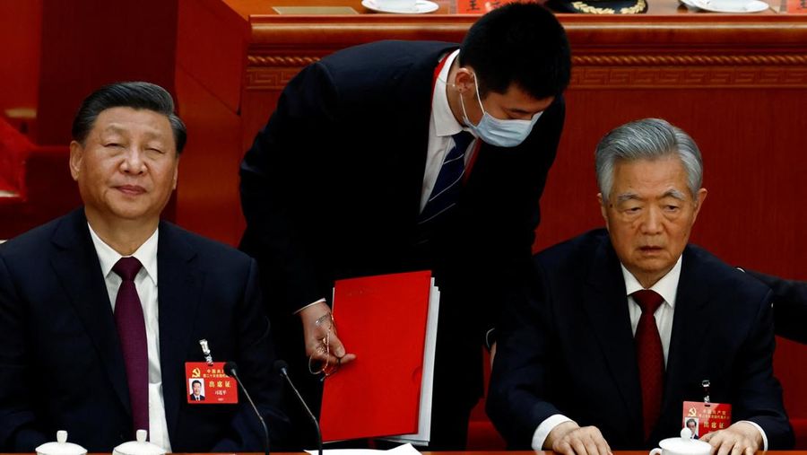Presiden Tiongkok Xi Jinping, kanan, mendengarkan bantuan saat dia duduk di sebelah Perdana Menteri Li Keqiang selama sesi penutupan Kongres Nasional Partai Komunis Tiongkok ke-20, di Aula Besar Rakyat pada Oktober 22, 2022 di Beijing, Cina. (Getty Images/Kevin Frayer)