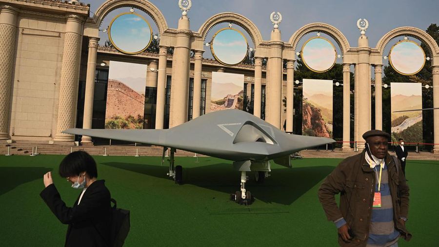 Orang-orang berdiri di depan drone tempur siluman GJ-11 yang dipajang di Beijing Exhibition Center, dengan judul 