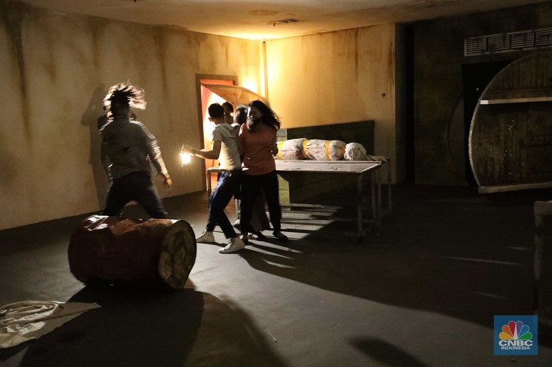 Pengunjung mencoba wahana Zombie Wars di Trans Studio Cibubur (TSM), Senin (24/10/22). Menyambut Halloween, TSM menghadirkan sesuatu yang mencekam sekaligus menantang di haunted house “Enigma Terror.  (CNBC Indonesia/ Tri Susilo)