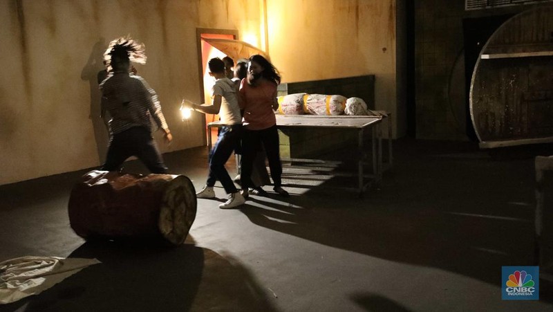 Pengunjung mencoba wahana Zombie Wars di Trans Studio Cibubur (TSM), Senin (24/10/22). Menyambut Halloween, TSM menghadirkan sesuatu yang mencekam sekaligus menantang di haunted house “Enigma Terror.  (CNBC Indonesia/ Tri Susilo)