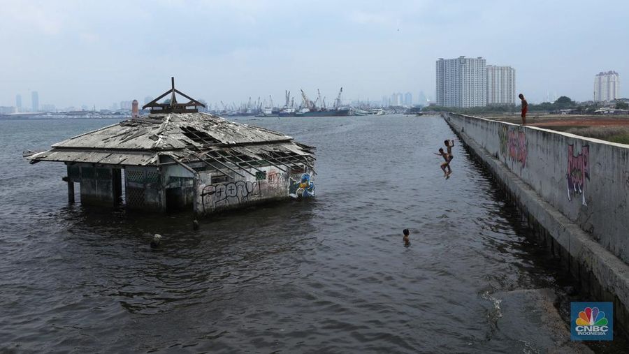 Sejumlah anak bermain di Masjid Wal-Adhuna yang tenggelam belasan tahun lalu akibat banjir rob di Muara Baru, Jakarta, Selasa (25/10/2021). Proyeksi lembaga nirlaba, Climate Central mendeteksi sejumlah wilayah di kawasan Pantai Utara (Pantura), Jawa terancam tenggelam atau terendam air pasang laut.  (CNBC Indonesia/ Tri Susilo)