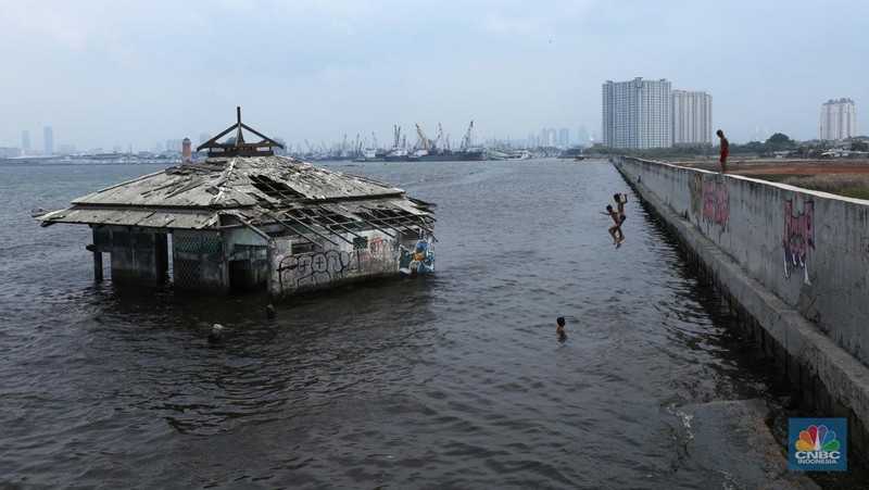 Sejumlah anak bermain di Masjid Wal-Adhuna yang tenggelam belasan tahun lalu akibat banjir rob di Muara Baru, Jakarta, Selasa (25/10/2021). Proyeksi lembaga nirlaba, Climate Central mendeteksi sejumlah wilayah di kawasan Pantai Utara (Pantura), Jawa terancam tenggelam atau terendam air pasang laut.  (CNBC Indonesia/ Tri Susilo)