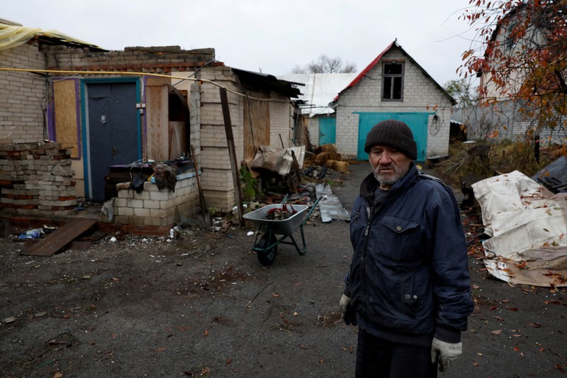 Myhaylo Yurkiv, 65, climbs out of the small bunker he stayed in for six months during fierce battles under Russian occupation which destroyed every home in the village and cut the village in two by the shelling of the bridge, leaving him now as the only person living on his side of the village, as Russia's invasion of Ukraine continues, in Tsupivka, Ukraine, October 26, 2022. REUTERS/Clodagh Kilcoyne     TPX IMAGES OF THE DAY