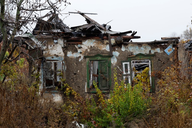 Myhaylo Yurkiv, 65, climbs out of the small bunker he stayed in for six months during fierce battles under Russian occupation which destroyed every home in the village and cut the village in two by the shelling of the bridge, leaving him now as the only person living on his side of the village, as Russia's invasion of Ukraine continues, in Tsupivka, Ukraine, October 26, 2022. REUTERS/Clodagh Kilcoyne     TPX IMAGES OF THE DAY