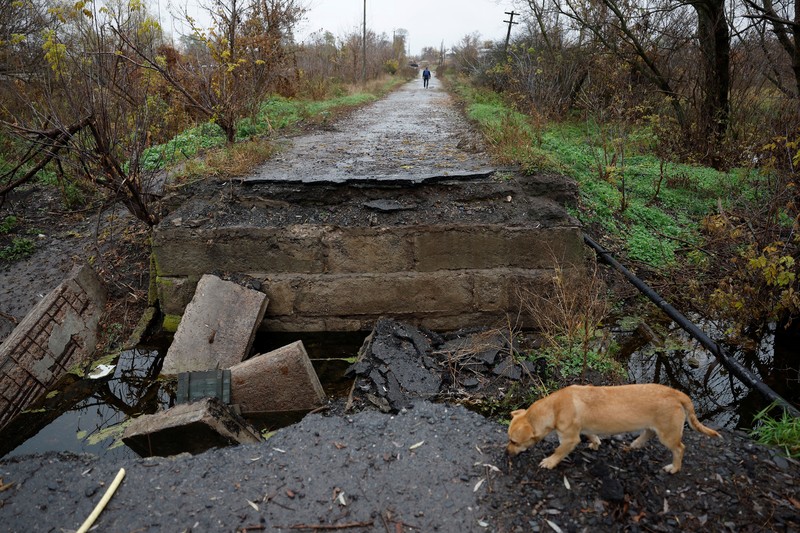 Myhaylo Yurkiv, 65, climbs out of the small bunker he stayed in for six months during fierce battles under Russian occupation which destroyed every home in the village and cut the village in two by the shelling of the bridge, leaving him now as the only person living on his side of the village, as Russia's invasion of Ukraine continues, in Tsupivka, Ukraine, October 26, 2022. REUTERS/Clodagh Kilcoyne     TPX IMAGES OF THE DAY