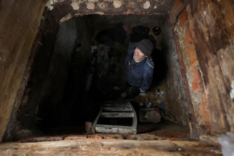 UKRAINE-CRISIS/KHARKIV-REGION Myhaylo Yurkiv, 65, climbs out of the small bunker he stayed in for six months during fierce battles under Russian occupation which destroyed every home in the village and cut the village in two by the shelling of the bridge, leaving him now as the only person living on his side of the village, as Russia's invasion of Ukraine continues, in Tsupivka, Ukraine, October 26, 2022. REUTERS/Clodagh Kilcoyne TPX IMAGES OF THE DAY