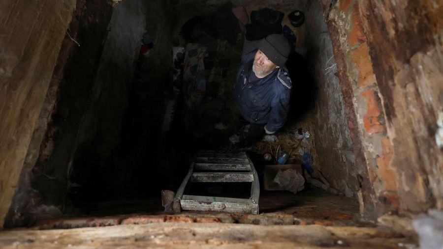 Myhaylo Yurkiv, 65, climbs out of the small bunker he stayed in for six months during fierce battles under Russian occupation which destroyed every home in the village and cut the village in two by the shelling of the bridge, leaving him now as the only person living on his side of the village, as Russia's invasion of Ukraine continues, in Tsupivka, Ukraine, October 26, 2022. REUTERS/Clodagh Kilcoyne     TPX IMAGES OF THE DAY