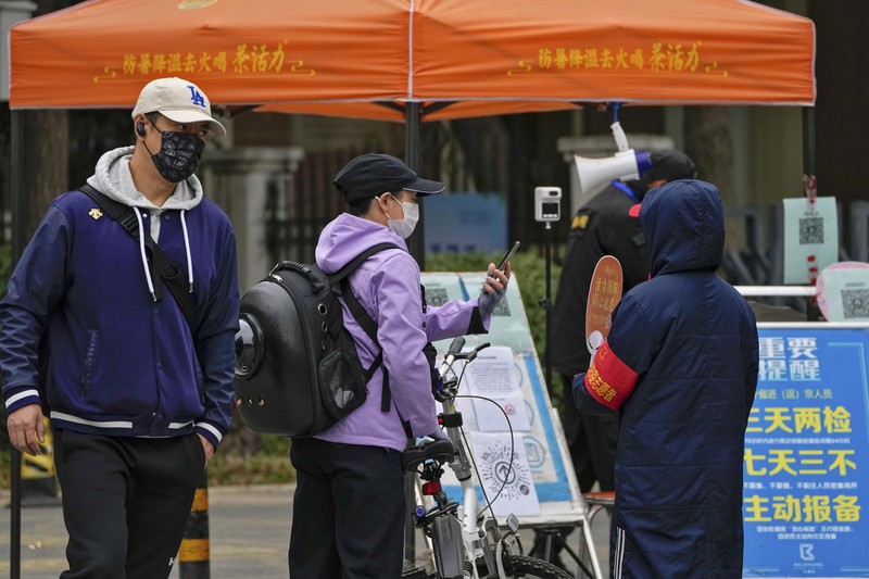 Virus Outbreak China Residents wearing face masks wait in line to get their routine COVID-19 throat swabs at a coronavirus testing site in Beijing, Thursday, Oct. 27, 2022. China's ruling Communist Party has so far shown no sign of easing the
