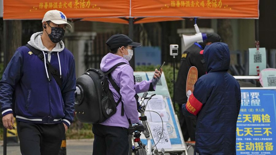 Residents wearing face masks wait in line to get their routine COVID-19 throat swabs at a coronavirus testing site in Beijing, Thursday, Oct. 27, 2022. China's ruling Communist Party has so far shown no sign of easing the 