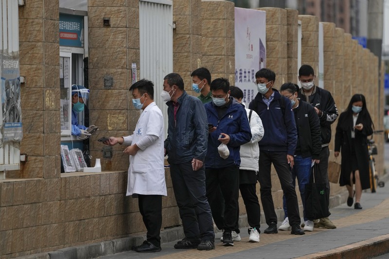 Virus Outbreak China Residents wearing face masks wait in line to get their routine COVID-19 throat swabs at a coronavirus testing site in Beijing, Thursday, Oct. 27, 2022. China's ruling Communist Party has so far shown no sign of easing the
