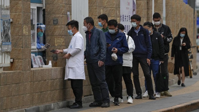 Residents wearing face masks wait in line to get their routine COVID-19 throat swabs at a coronavirus testing site in Beijing, Thursday, Oct. 27, 2022. China's ruling Communist Party has so far shown no sign of easing the 