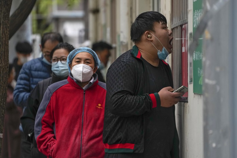 Virus Outbreak China Residents wearing face masks wait in line to get their routine COVID-19 throat swabs at a coronavirus testing site in Beijing, Thursday, Oct. 27, 2022. China's ruling Communist Party has so far shown no sign of easing the