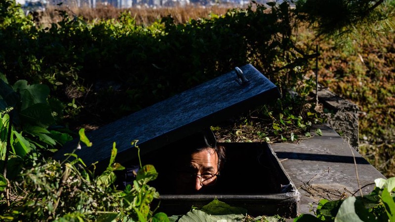 TOPSHOT - This picture taken on October 17, 2022 shows architecture professor Lee Tae-goo opening a hatch door as he prepares to climb out of his bunker, which is buried one metre (three feet) deep and can protect from the radiation fallout of a nuclear blast on his property in Jecheon, some 74 miles (120 km) southeast of the capital Seoul. - If North Korea unleashes a nuclear attack on the South, architecture professor Lee Tae-goo plans to retreat to his purpose-built bunker -- which was funded by a government grant -- and stay underground for at least two weeks to avoid radiation poisoning. - To go with 'SKOREA-NKOREA-NUCLEAR-BUNKER,FOCUS' by Cat Barton and Kang Jin-kyu (Photo by Anthony WALLACE / AFP) / To go with 'SKOREA-NKOREA-NUCLEAR-BUNKER,FOCUS' by Cat Barton and Kang Jin-kyu (Photo by ANTHONY WALLACE/AFP via Getty Images)
