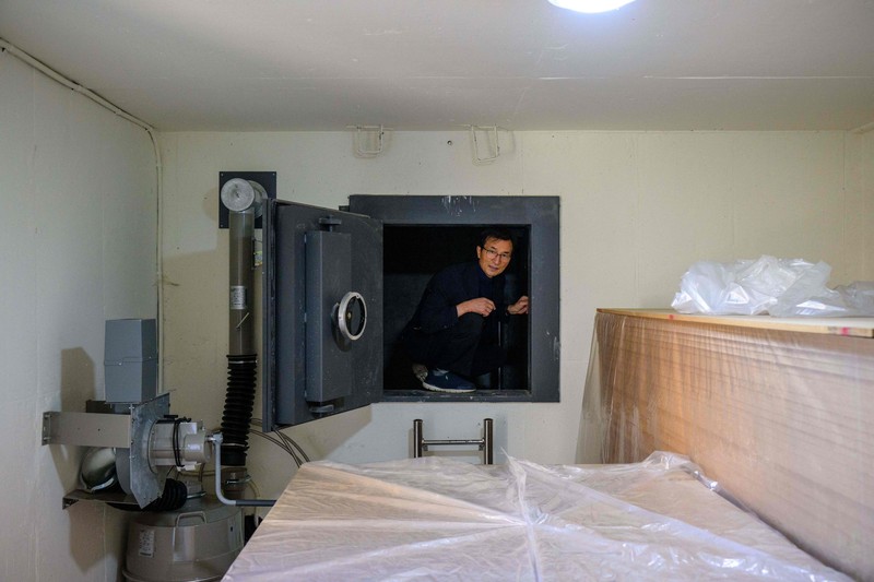 1244258723 TOPSHOT - This picture taken on October 17, 2022 shows architecture professor Lee Tae-goo opening a hatch door as he prepares to climb out of his bunker, which is buried one metre (three feet) deep and can protect from the radiation fallout of a nuclear blast on his property in Jecheon, some 74 miles (120 km) southeast of the capital Seoul. - If North Korea unleashes a nuclear attack on the South, architecture professor Lee Tae-goo plans to retreat to his purpose-built bunker -- which was funded by a government grant -- and stay underground for at least two weeks to avoid radiation poisoning. - To go with 'SKOREA-NKOREA-NUCLEAR-BUNKER,FOCUS' by Cat Barton and Kang Jin-kyu (Photo by Anthony WALLACE / AFP) / To go with 'SKOREA-NKOREA-NUCLEAR-BUNKER,FOCUS' by Cat Barton and Kang Jin-kyu (Photo by ANTHONY WALLACE/AFP via Getty Images)