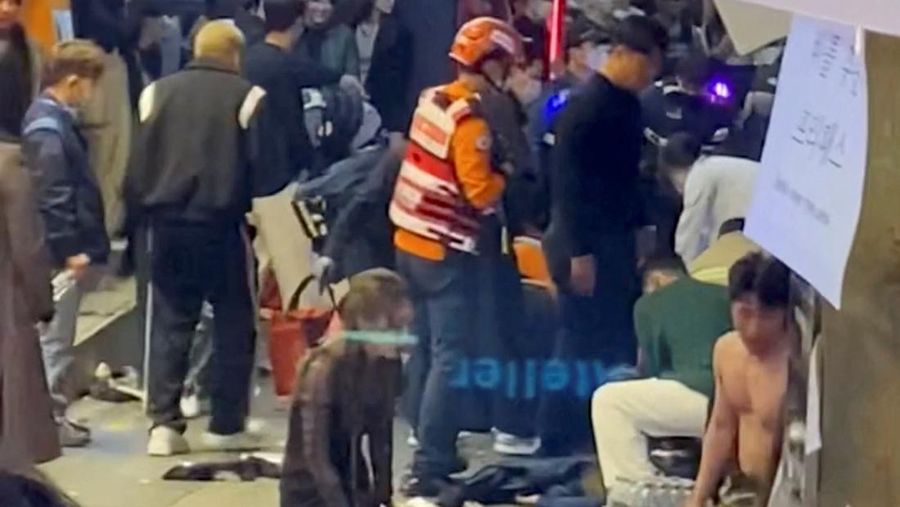Sejumlah personel darurat dan seorang pria yang mencoba memberikan pertolongan pertama darurat kepada seorang wanita, setelah terinjak-injak, selama festival Halloween di Seoul, Korea Selatan, 30 Oktober 2022, dalam tangkapan layar yang diperoleh dari video media sosial. @KENFALLAS/via REUTERS
