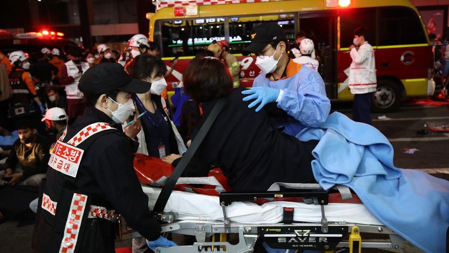Petugas layanan darurat merawat orang yang terluka setelah terinjak-injak dalam pesta Halloween di Seoul, Korea Selatan (30/10). (Chung Sung-Jun/Getty Images)
