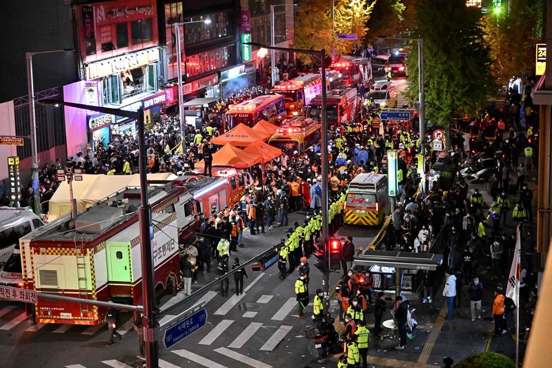 Kerumunan terlihat di sekitar area, di mana puluhan orang menderita serangan jantung usai pawai Halloween, di distrik kehidupan malam populer Itaewon di Seoul, Korea Selatan (30/10). (Photo by JUNG YEON-JE/AFP via Getty Images)