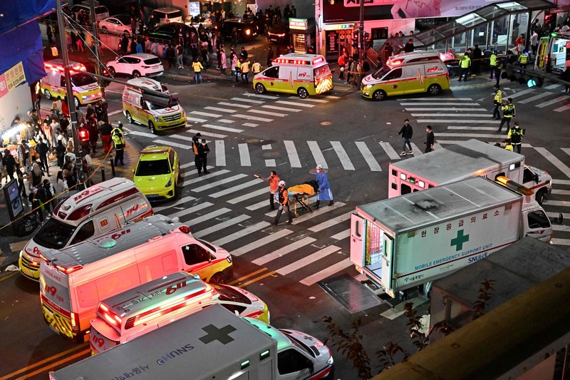 Kerumunan terlihat di sekitar area, di mana puluhan orang menderita serangan jantung usai pawai Halloween, di distrik kehidupan malam populer Itaewon di Seoul, Korea Selatan (30/10). (Photo by JUNG YEON-JE/AFP via Getty Images)