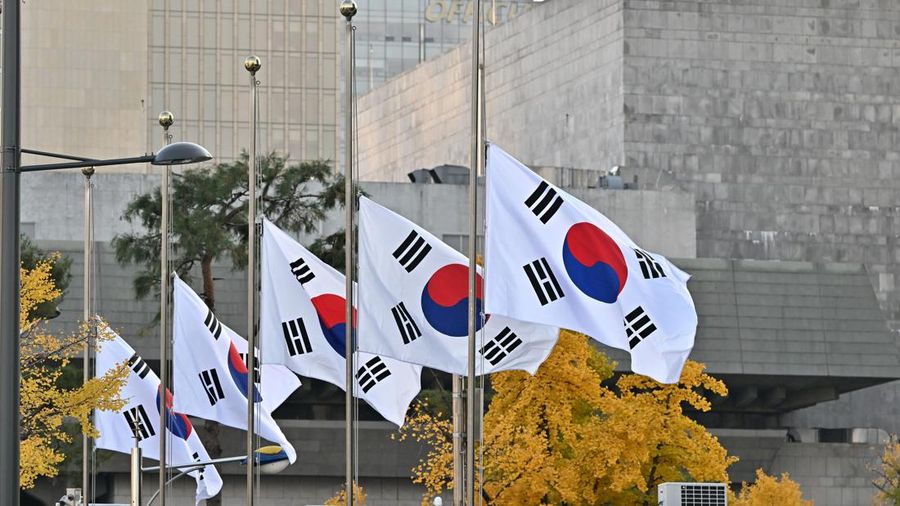 Bendera nasional Korea Selatan berkibar setengah tiang di kompleks pemerintah di Seoul pada 30 Oktober 2022, setelah penyerbuan Halloween yang mematikan di distrik Itaewon yang populer di ibu kota. (AFP via Getty Images/JUNG YEON-JE)