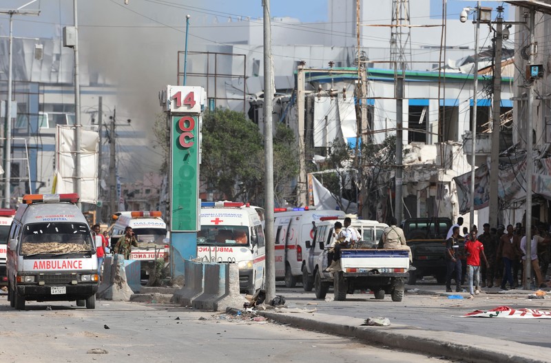 A Somali soldier walks through the scene of a double car-bomb attack in Mogadishu, Somalia, Saturday Oct. 29, 2022. Two car bombs exploded Saturday at a busy junction in Somalia's capital near key government offices, leaving 