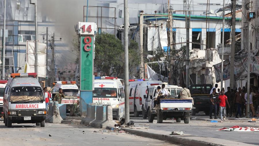 A Somali soldier walks through the scene of a double car-bomb attack in Mogadishu, Somalia, Saturday Oct. 29, 2022. Two car bombs exploded Saturday at a busy junction in Somalia's capital near key government offices, leaving 