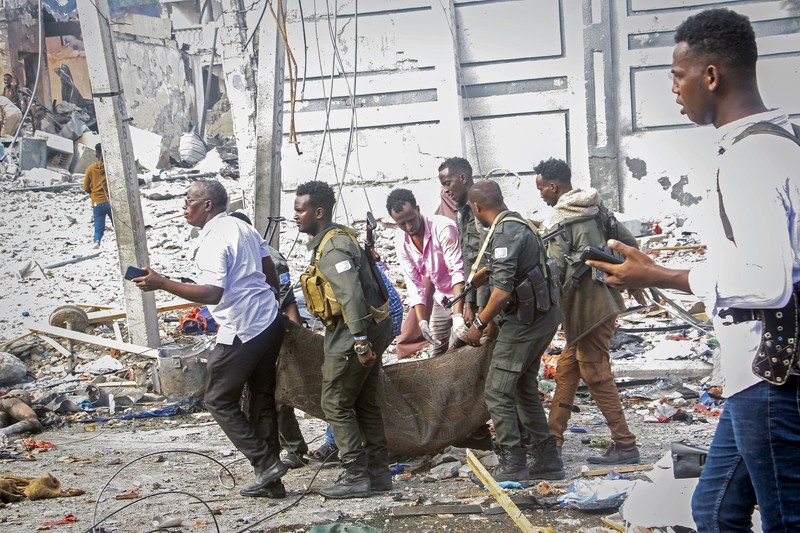 A Somali soldier walks through the scene of a double car-bomb attack in Mogadishu, Somalia, Saturday Oct. 29, 2022. Two car bombs exploded Saturday at a busy junction in Somalia's capital near key government offices, leaving 