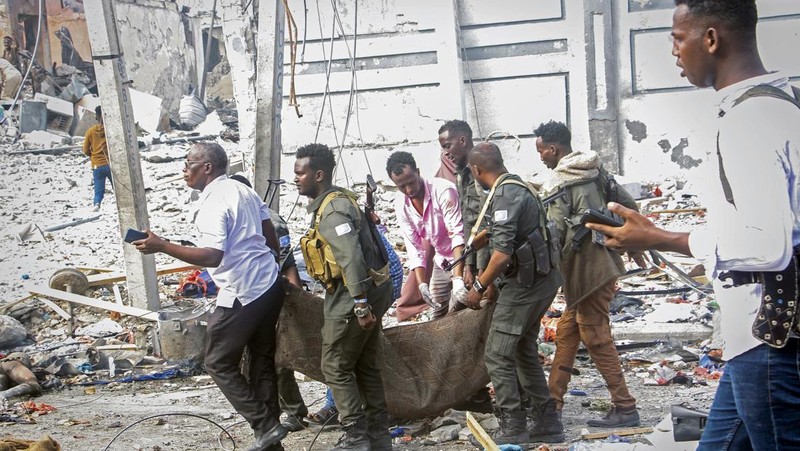 A Somali soldier walks through the scene of a double car-bomb attack in Mogadishu, Somalia, Saturday Oct. 29, 2022. Two car bombs exploded Saturday at a busy junction in Somalia's capital near key government offices, leaving 