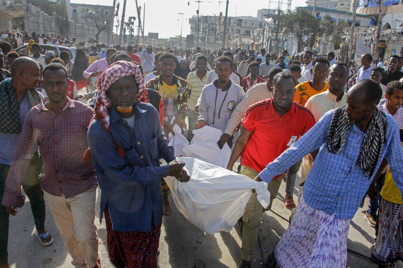 A Somali soldier walks through the scene of a double car-bomb attack in Mogadishu, Somalia, Saturday Oct. 29, 2022. Two car bombs exploded Saturday at a busy junction in Somalia's capital near key government offices, leaving 