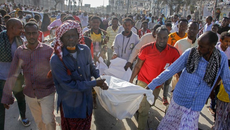 A Somali soldier walks through the scene of a double car-bomb attack in Mogadishu, Somalia, Saturday Oct. 29, 2022. Two car bombs exploded Saturday at a busy junction in Somalia's capital near key government offices, leaving 
