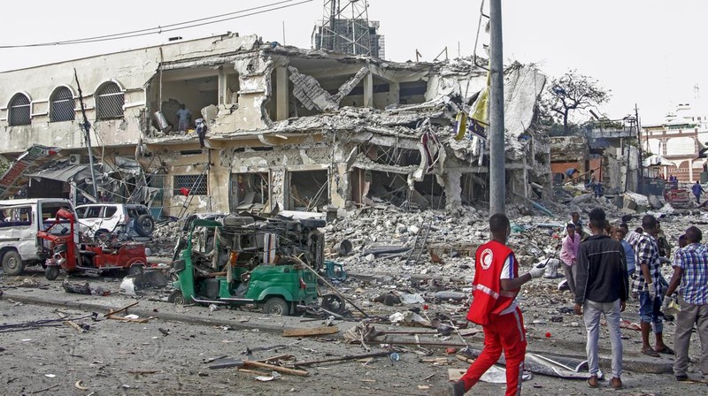A Somali soldier walks through the scene of a double car-bomb attack in Mogadishu, Somalia, Saturday Oct. 29, 2022. Two car bombs exploded Saturday at a busy junction in Somalia's capital near key government offices, leaving 