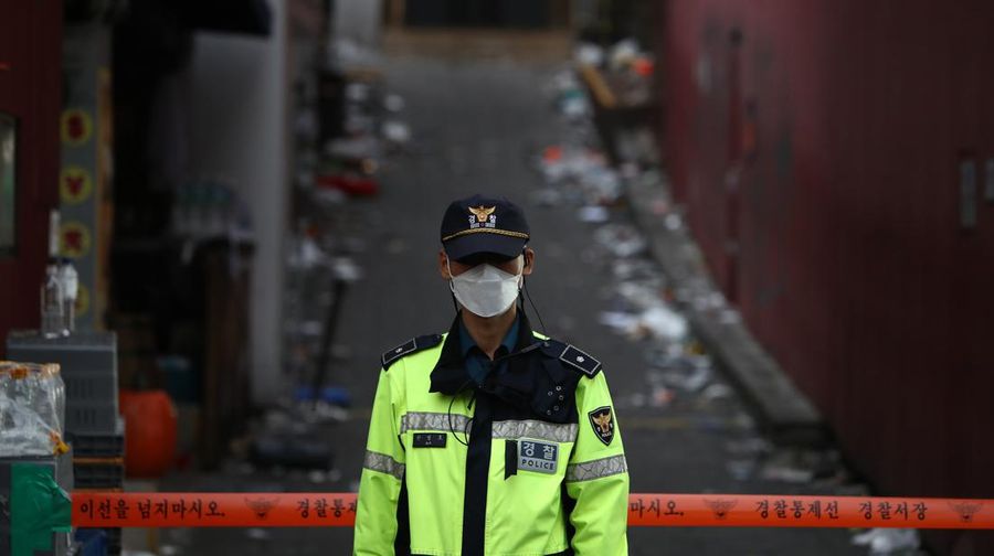 SEOUL, SOUTH KOREA - OCTOBER 31: A police stands guard in front of the scene of a deadly stampede during a Halloween festival on October 31, 2022 in Seoul, South Korea. One hundred and fifty-one people have been reported killed and at least 150 others were injured in a deadly stampede in Seoul's Itaewon district, after huge crowds of people gathered for Halloween parties, according to fire authorities. (Photo by Chung Sung-Jun/Getty Images)