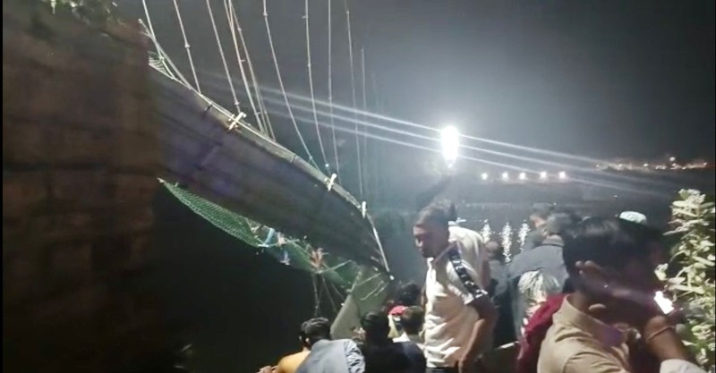 Setidaknya 60 orang tewas setelah satu jembatan gantung di India yang sudah berusia 100 tahun ambruk pada Minggu (30/10). (AP/Rajesh Ambaliya) Setidaknya 60 orang tewas setelah satu jembatan gantung di India yang sudah berusia 100 tahun ambruk pada Minggu (30/10). (AP/Rajesh Ambaliya)