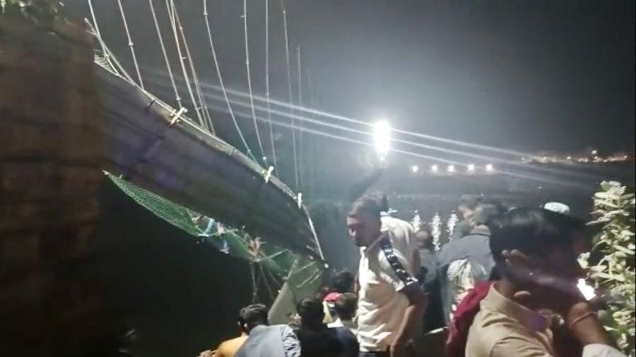 Setidaknya 60 orang tewas setelah satu jembatan gantung di India yang sudah berusia 100 tahun ambruk pada Minggu (30/10). (AP/Rajesh Ambaliya)