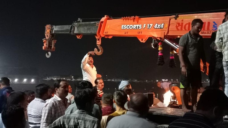 Setidaknya 60 orang tewas setelah satu jembatan gantung di India yang sudah berusia 100 tahun ambruk pada Minggu (30/10). (AP/Rajesh Ambaliya)