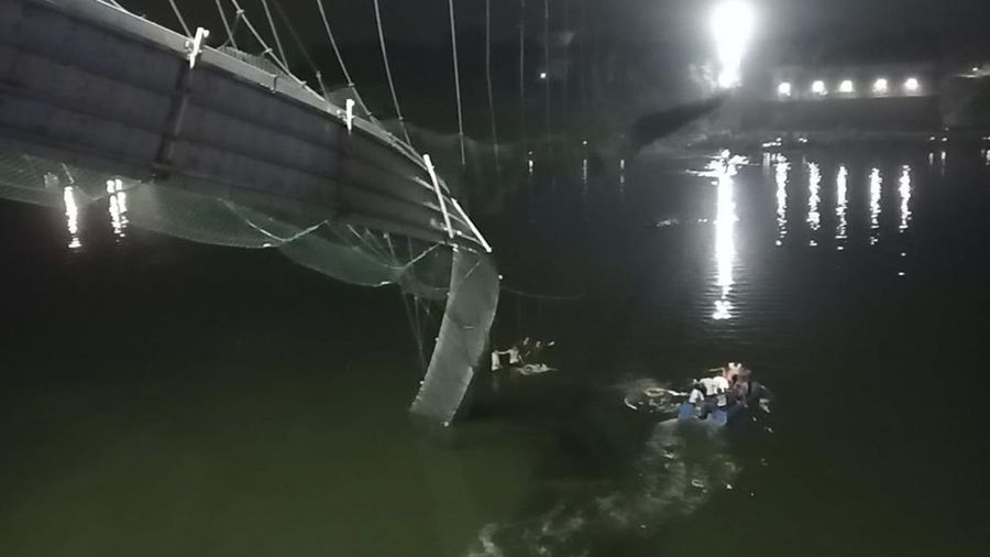 Setidaknya 60 orang tewas setelah satu jembatan gantung di India yang sudah berusia 100 tahun ambruk pada Minggu (30/10). (AP/Rajesh Ambaliya)