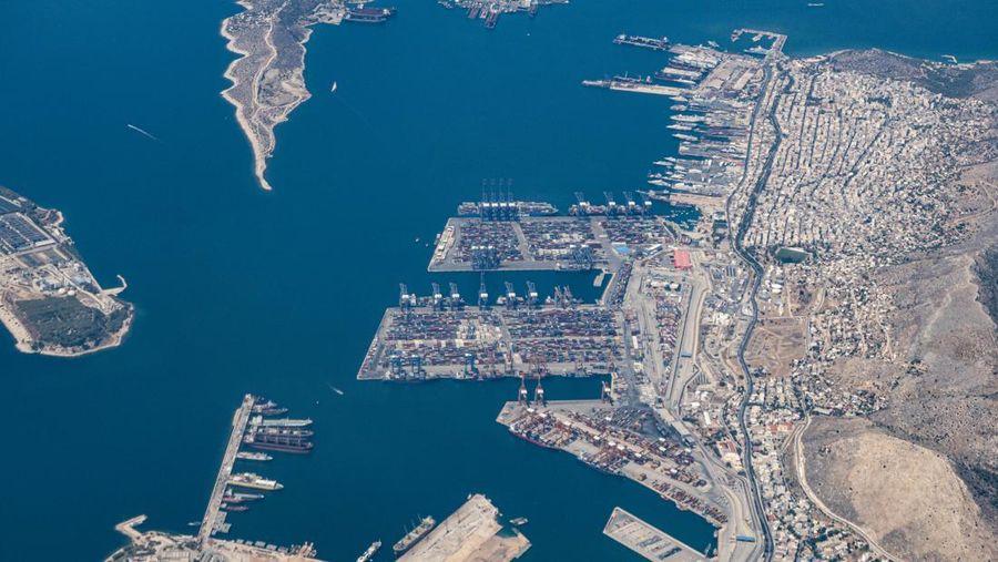 Aerial view from an airplane window of Pireaus port GRPIR. View of large freighter ships, nautical vessels docked while loading - unloading containers and cargo via cranes at the piers of the port at the logistics and container terminal of Perama near the commercial port of Piraeus with thousands of stacked containers. Pireas Port is a logistics hub, the largest Greek port and one of the largest in Europe, serving Athens, Attica and Greece since ancient times. The majority of Port of Piraeus is owned by China COSCO Shipping, the third largest container ship company in the world. As of 2021 the total capacity is at 8,3m TEUs. Piraeus, Greece on August 7, 2022 (Nicolas Economou/NurPhoto via Getty Images)