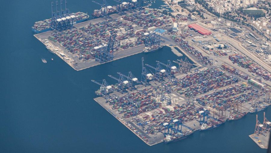 Aerial view from an airplane window of Pireaus port GRPIR. View of large freighter ships, nautical vessels docked while loading - unloading containers and cargo via cranes at the piers of the port at the logistics and container terminal of Perama near the commercial port of Piraeus with thousands of stacked containers. Pireas Port is a logistics hub, the largest Greek port and one of the largest in Europe, serving Athens, Attica and Greece since ancient times. The majority of Port of Piraeus is owned by China COSCO Shipping, the third largest container ship company in the world. As of 2021 the total capacity is at 8,3m TEUs. Piraeus, Greece on August 7, 2022 (Nicolas Economou/NurPhoto via Getty Images)