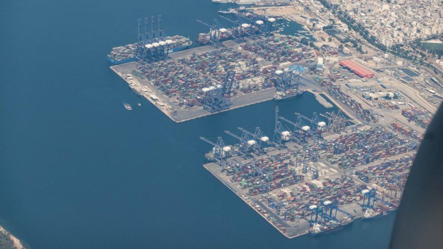 Aerial view from an airplane window of Pireaus port GRPIR. View of large freighter ships, nautical vessels docked while loading - unloading containers and cargo via cranes at the piers of the port at the logistics and container terminal of Perama near the commercial port of Piraeus with thousands of stacked containers. Pireas Port is a logistics hub, the largest Greek port and one of the largest in Europe, serving Athens, Attica and Greece since ancient times. The majority of Port of Piraeus is owned by China COSCO Shipping, the third largest container ship company in the world. As of 2021 the total capacity is at 8,3m TEUs. Piraeus, Greece on August 7, 2022 (Nicolas Economou/NurPhoto via Getty Images)