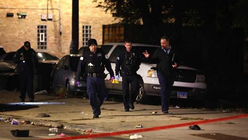 Chicago police and emergency medical responders work at the scene of a mass shooting near Polk Street and California Avenue on the city's West Side on Monday, Oct. 31, 2022.  Chicago Police say several people were injured in a drive-by shooting Halloween night, including three children (E. Jason Wambsgans /Chicago Tribune via AP)