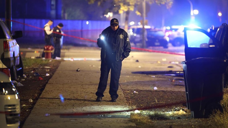 Chicago police and emergency medical responders work at the scene of a mass shooting near Polk Street and California Avenue on the city's West Side on Monday, Oct. 31, 2022.  Chicago Police say several people were injured in a drive-by shooting Halloween night, including three children (E. Jason Wambsgans /Chicago Tribune via AP)