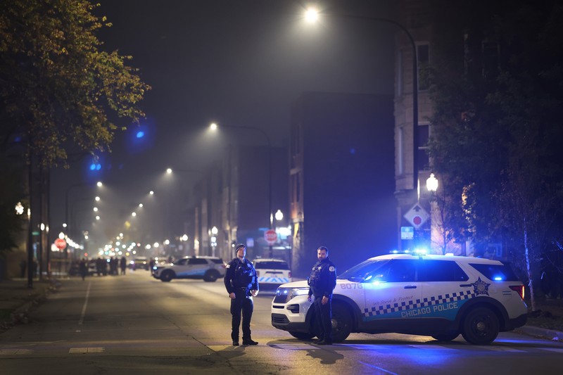 Chicago police and emergency medical responders work at the scene of a mass shooting near Polk Street and California Avenue on the city's West Side on Monday, Oct. 31, 2022.  Chicago Police say several people were injured in a drive-by shooting Halloween night, including three children (E. Jason Wambsgans /Chicago Tribune via AP)