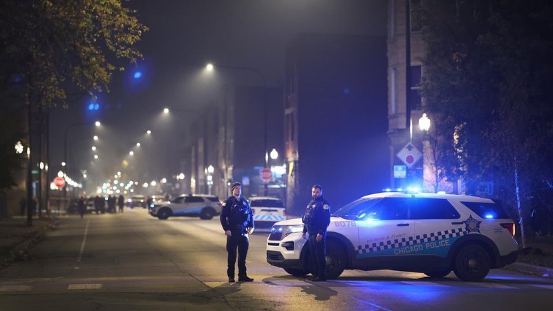 Chicago police and emergency medical responders work at the scene of a mass shooting near Polk Street and California Avenue on the city's West Side on Monday, Oct. 31, 2022.  Chicago Police say several people were injured in a drive-by shooting Halloween night, including three children (E. Jason Wambsgans /Chicago Tribune via AP)