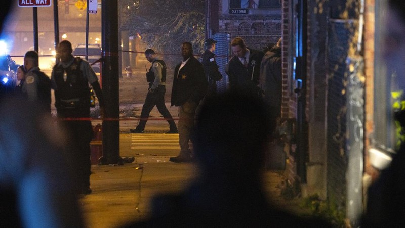 Chicago police and emergency medical responders work at the scene of a mass shooting near Polk Street and California Avenue on the city's West Side on Monday, Oct. 31, 2022.  Chicago Police say several people were injured in a drive-by shooting Halloween night, including three children (E. Jason Wambsgans /Chicago Tribune via AP)