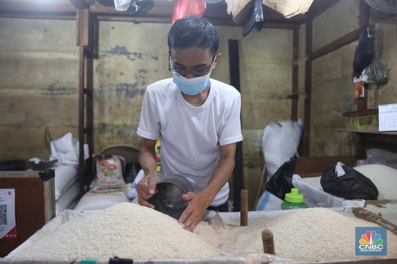 Pedagang menakar beras literan di pasar Kebayoran Lama, Jakarta, 1/11. Ekonomi Indonesia mengalami deflasi pada Oktober 2022 sekaligus angka inflasi menurun secara tahunan. (CNBC Indonesia/ Muhammad Sabki)