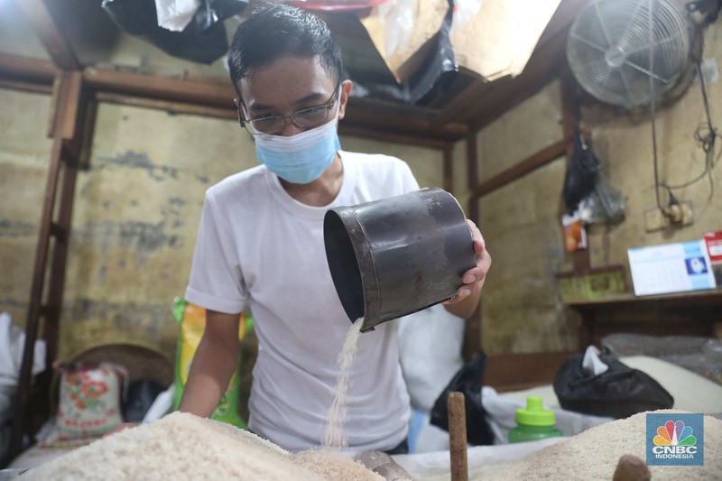 Pedagang menakar beras literan di pasar Kebayoran Lama, Jakarta, 1/11. Ekonomi Indonesia mengalami deflasi pada Oktober 2022 sekaligus angka inflasi menurun secara tahunan. (CNBC Indonesia/ Muhammad Sabki)