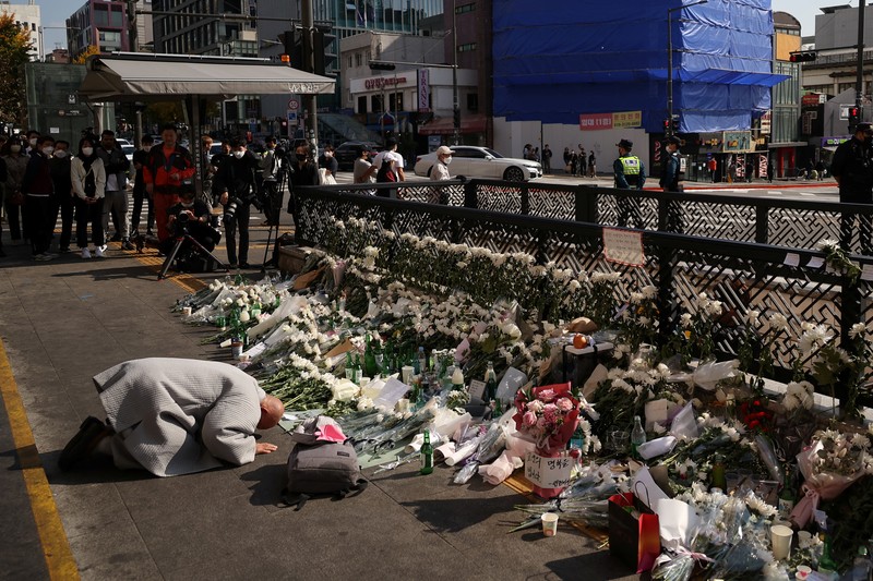 Seorang pria memberikan penghormatan di dekat lokasi penyerbuan yang terjadi selama perayaan Halloween, di Seoul, Korea Selatan, 31 Oktober 2022. (REUTERS/KIM HONG-JI)