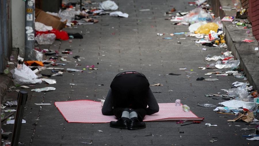 Seorang pria memberikan penghormatan di dekat lokasi penyerbuan yang terjadi selama perayaan Halloween, di Seoul, Korea Selatan, 31 Oktober 2022. (REUTERS/KIM HONG-JI)