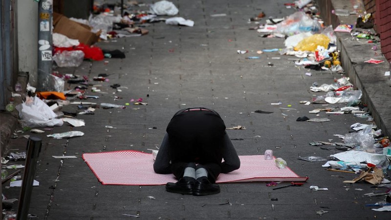 Seorang pria memberikan penghormatan di dekat lokasi penyerbuan yang terjadi selama perayaan Halloween, di Seoul, Korea Selatan, 31 Oktober 2022. (REUTERS/KIM HONG-JI)